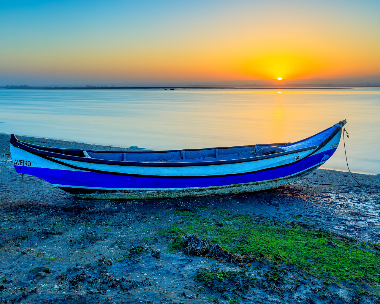 Лодка на берегу реки на закате солнца