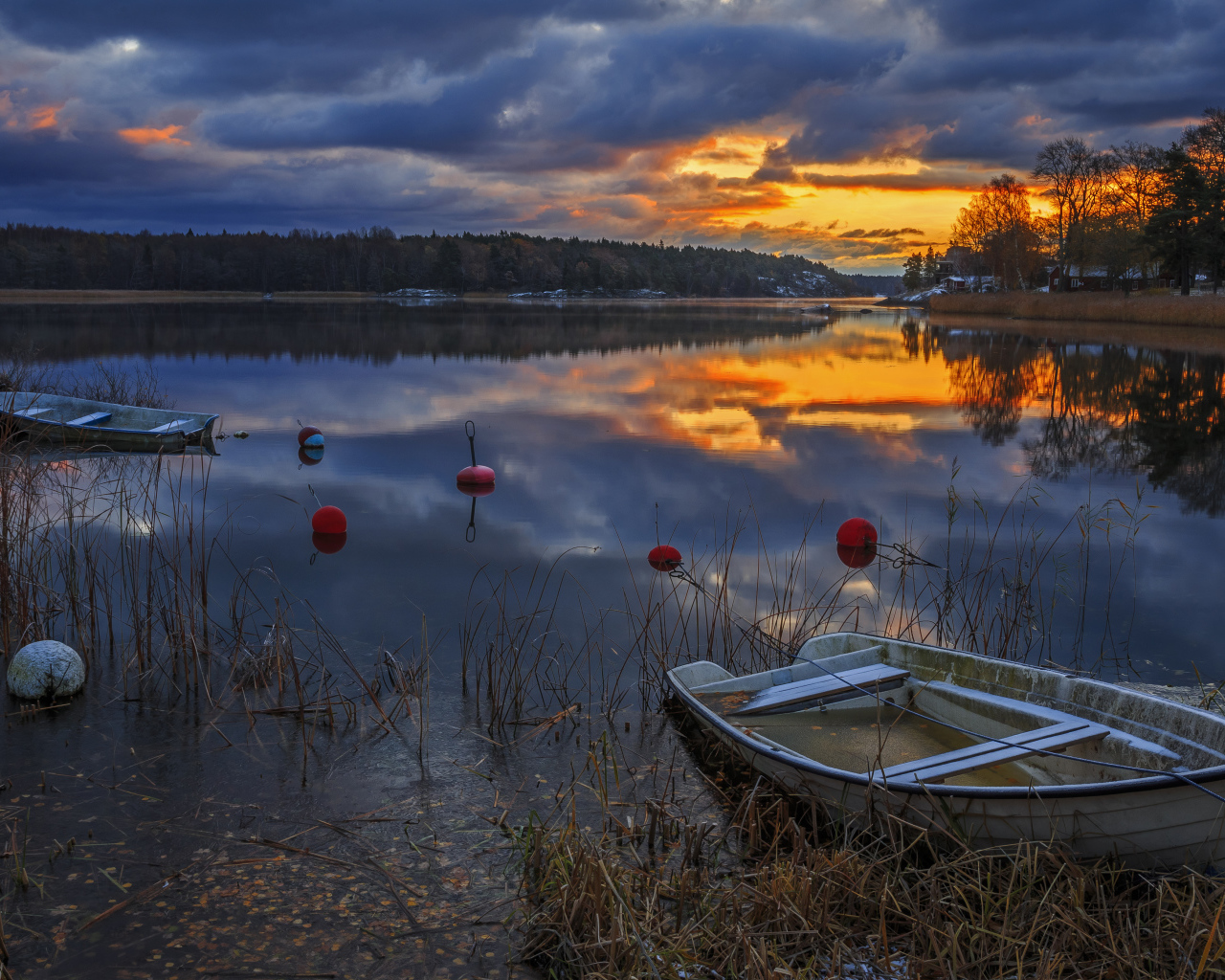 Лодки в тихом лесном озере на закате солнца