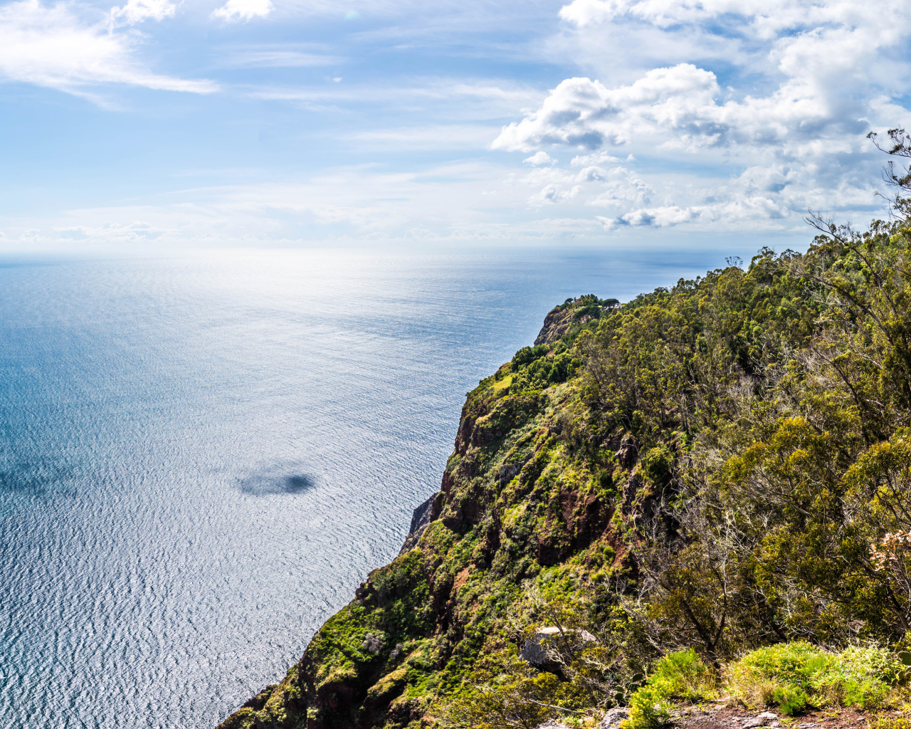 Утес на берегу океана на фоне красивого голубого неба