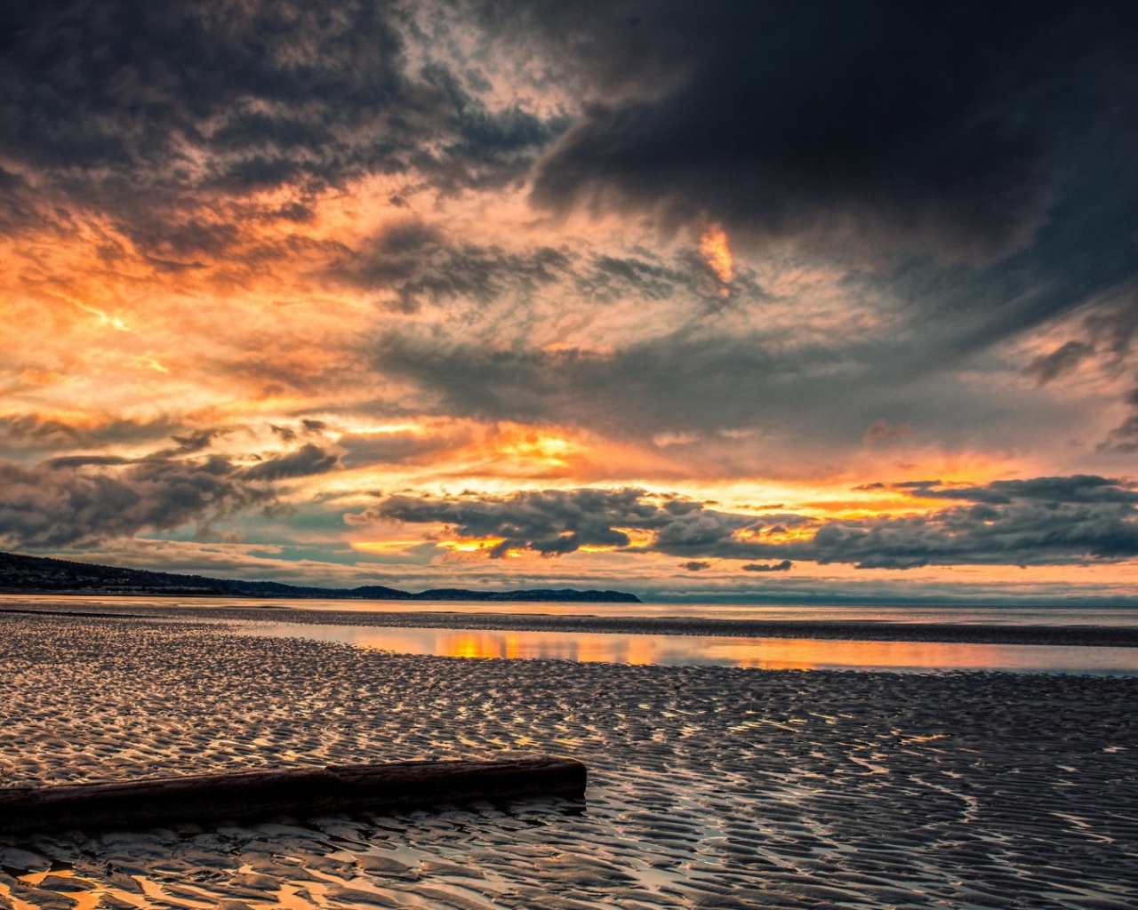 Прохладный закат в хмуром небе  над пляжем