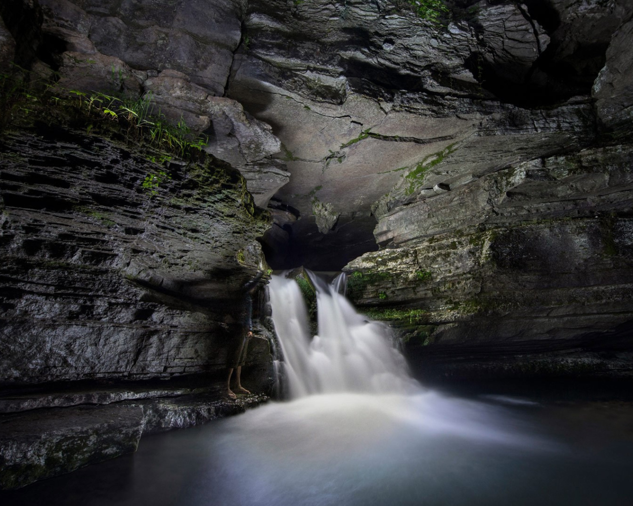 Быстрый водопад в каменной пещере 