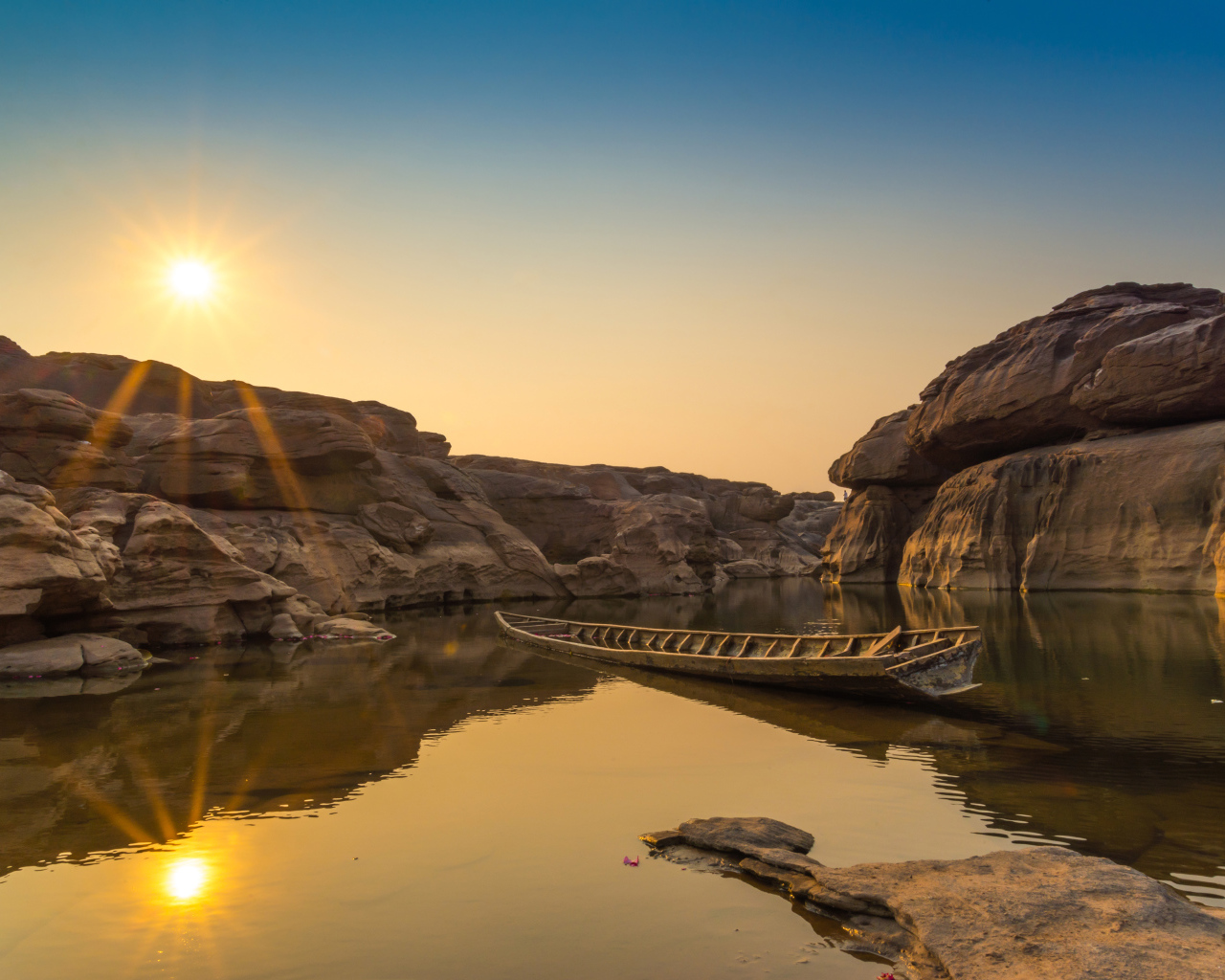 Лодна на озере между скал на рассвете