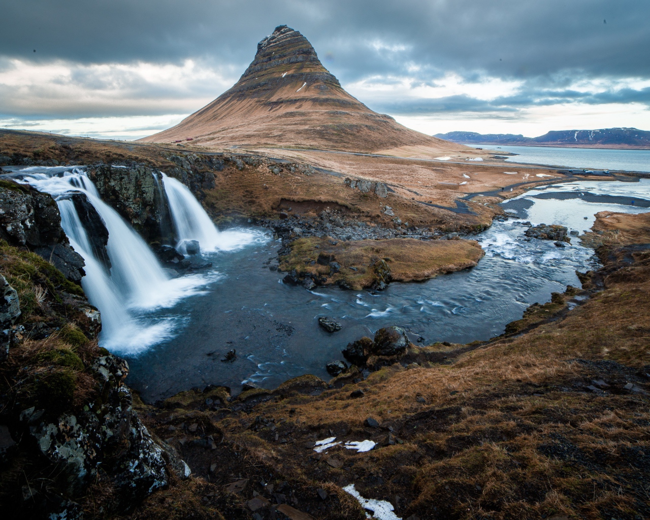 Гора и водопад у реки в Исландии  