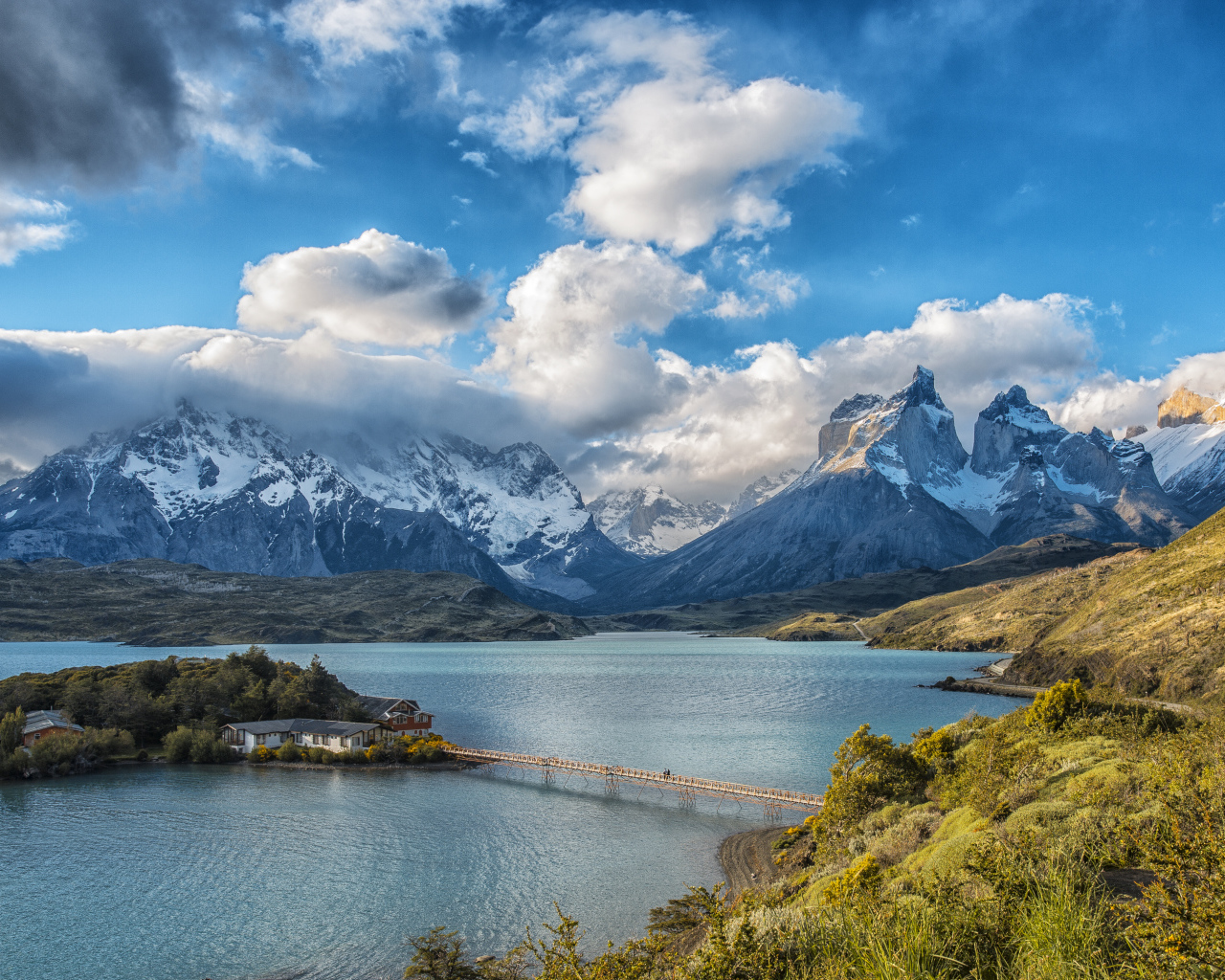 Горы под красивыми белыми облаками у озера в национальном парке Торрес-дель-Пайне, Чили