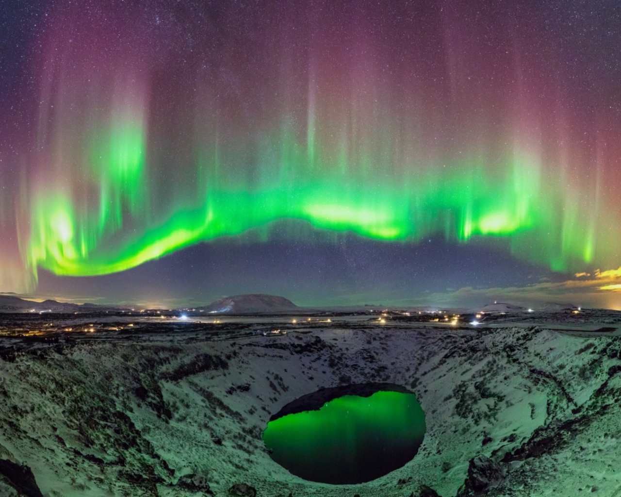 Северное сияние над заснеженным кратером вулкана 