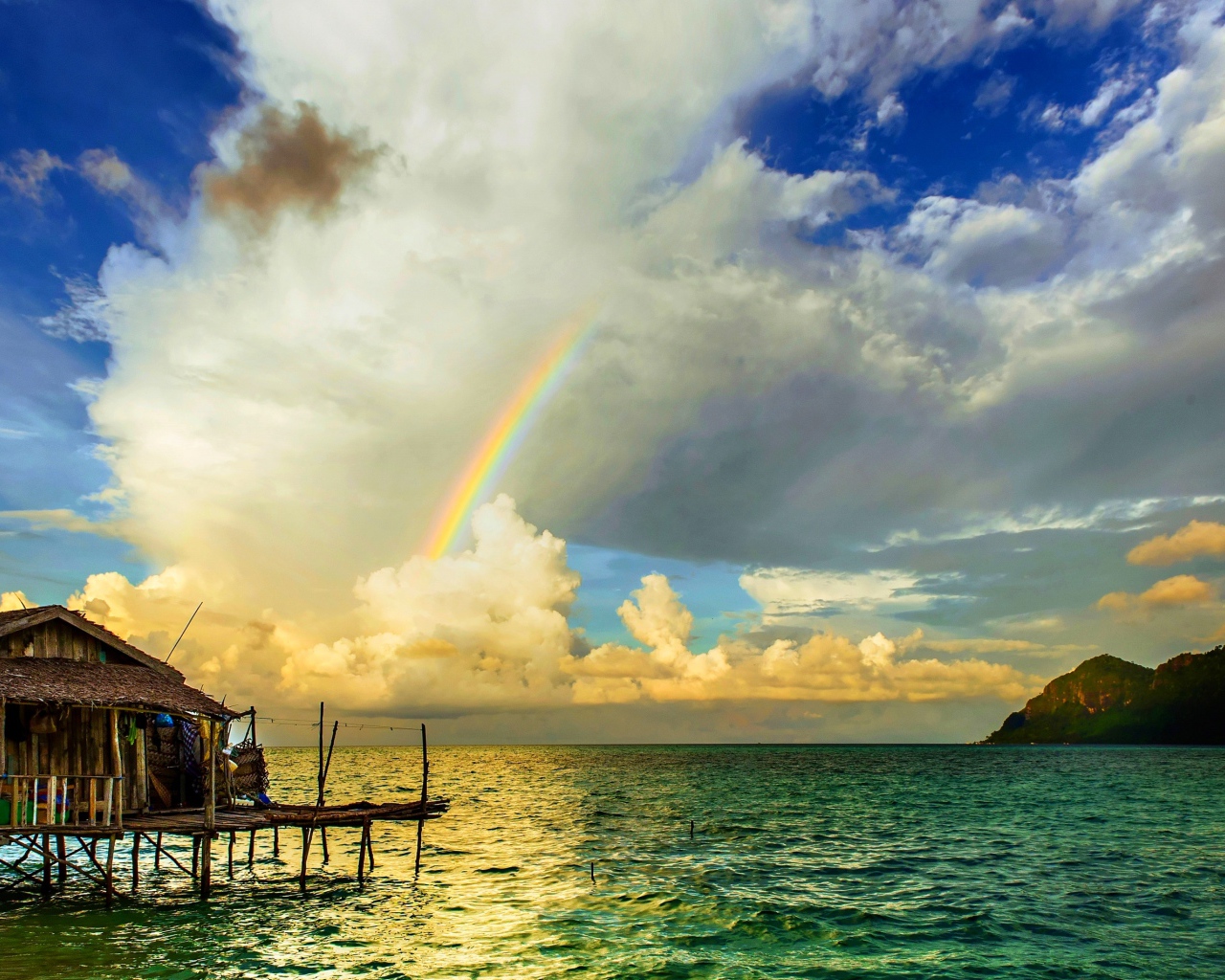 Радуга  над бунгало на тропическим пляжем 