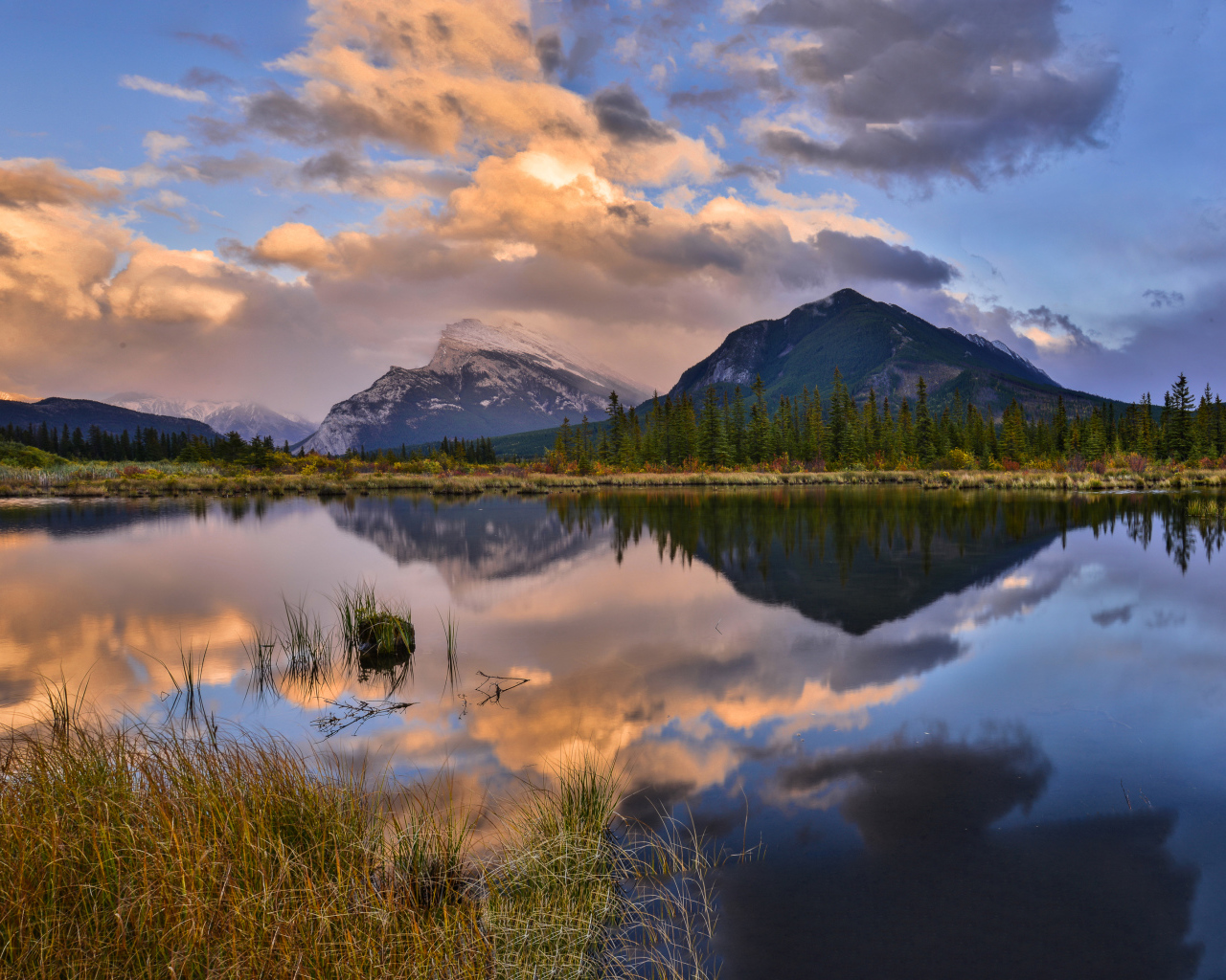 Небо и горы отражаются в чистой воде озера 