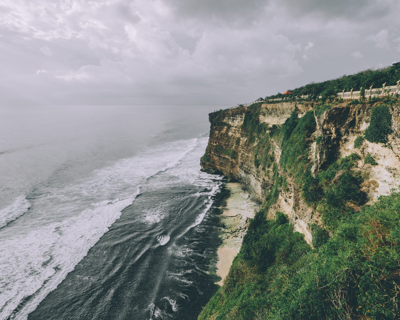 Бушующие волны у зеленого утеса 