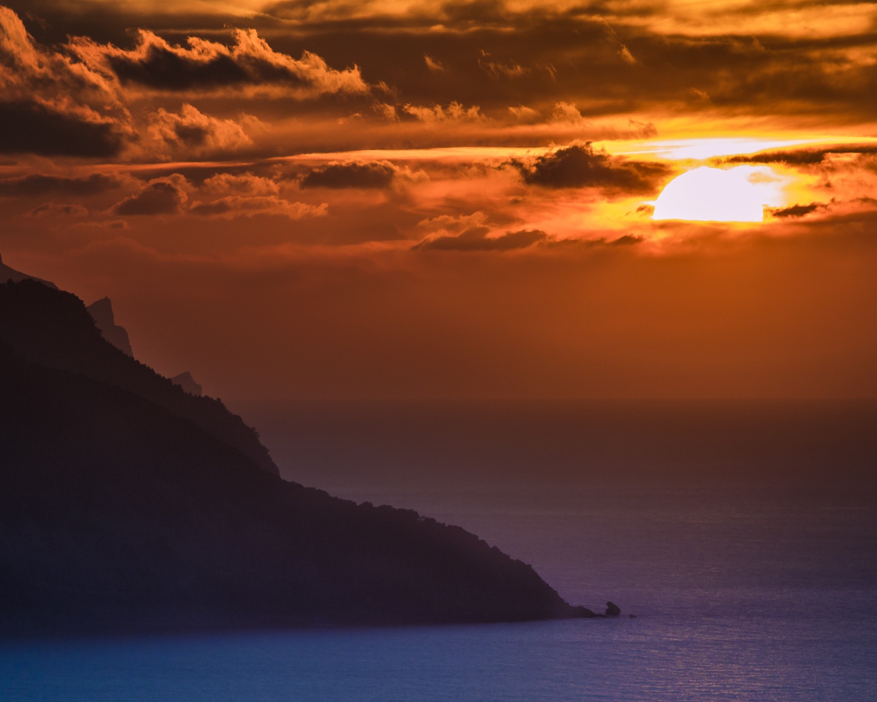 Туманный закат солнца над океанской гладью 