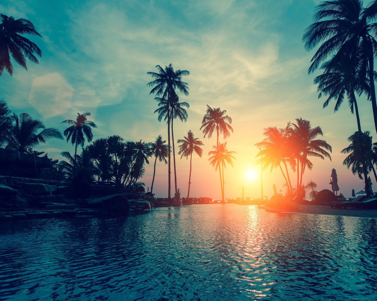 Закат яркого летнего солнца над тропическим пляжем