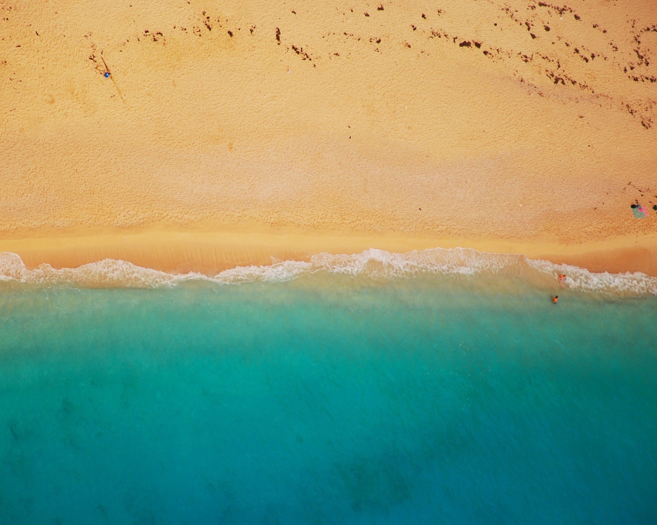Желтый песок соединяется с голубой водой 