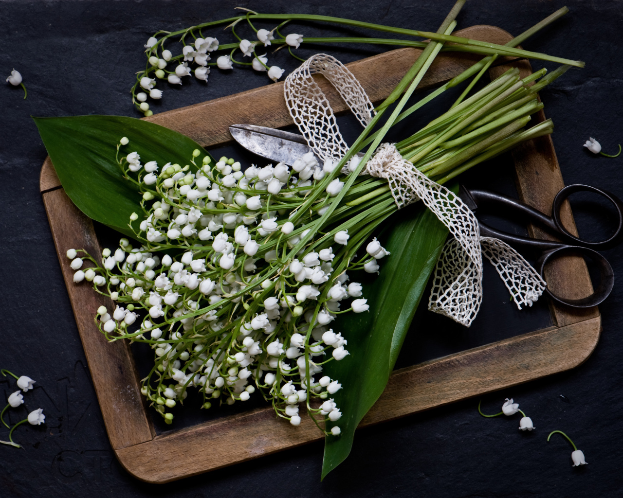 Букет белых ландышей с ножницами на столе
