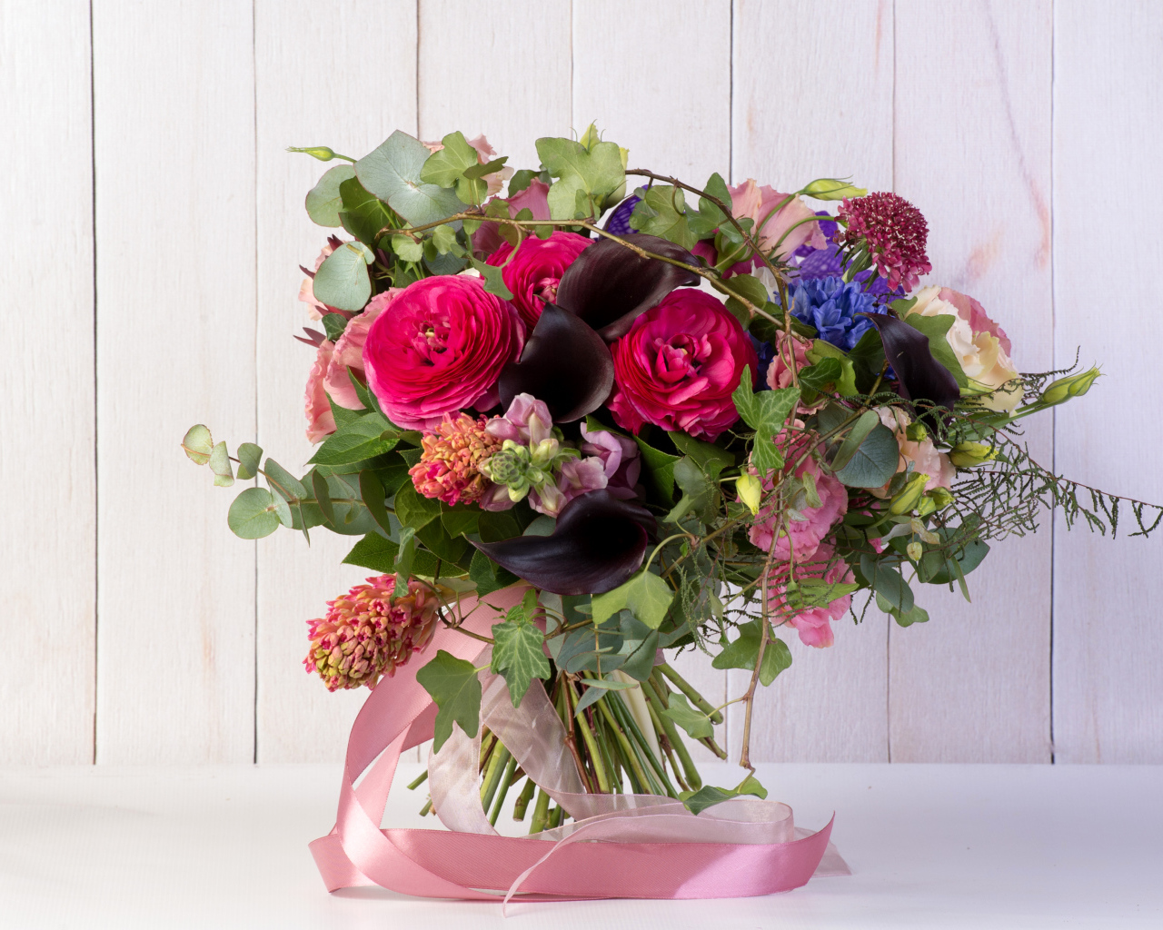 Праздничный букет с розовыми лентами на столе