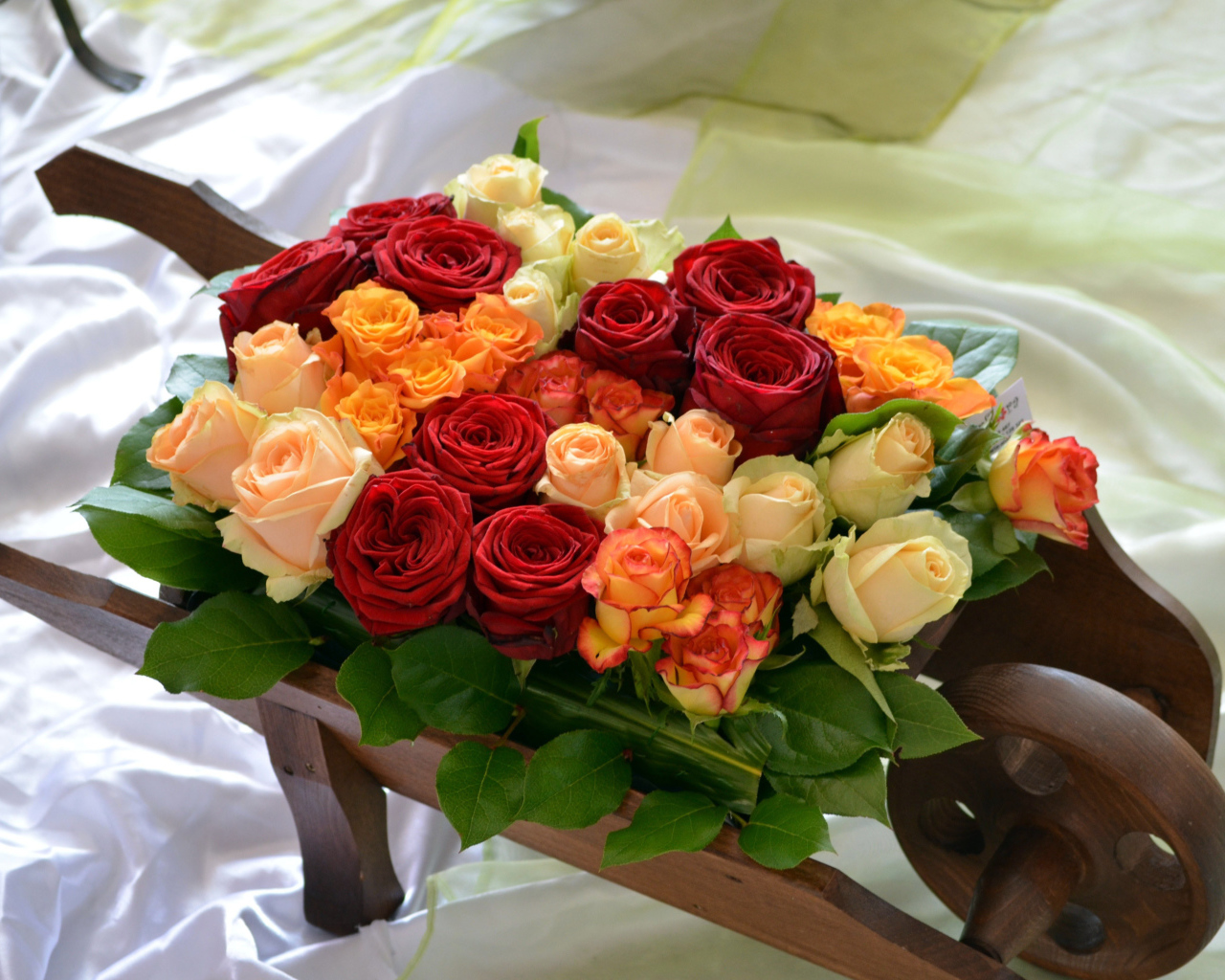 Маленькая деревянная тележка с букетом роз