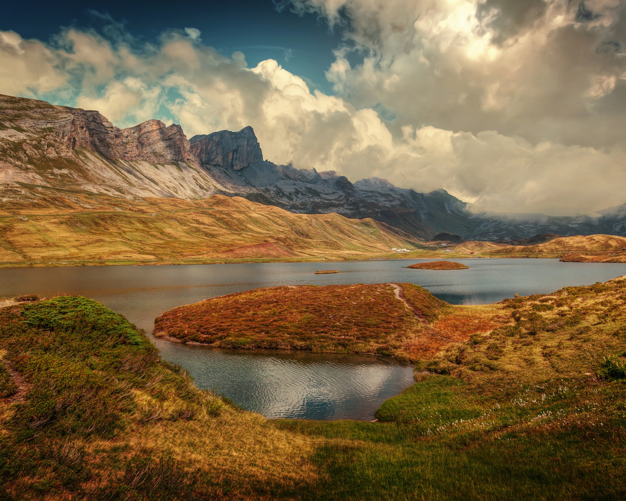 Горы под белыми облаками у озера в Швейцарии