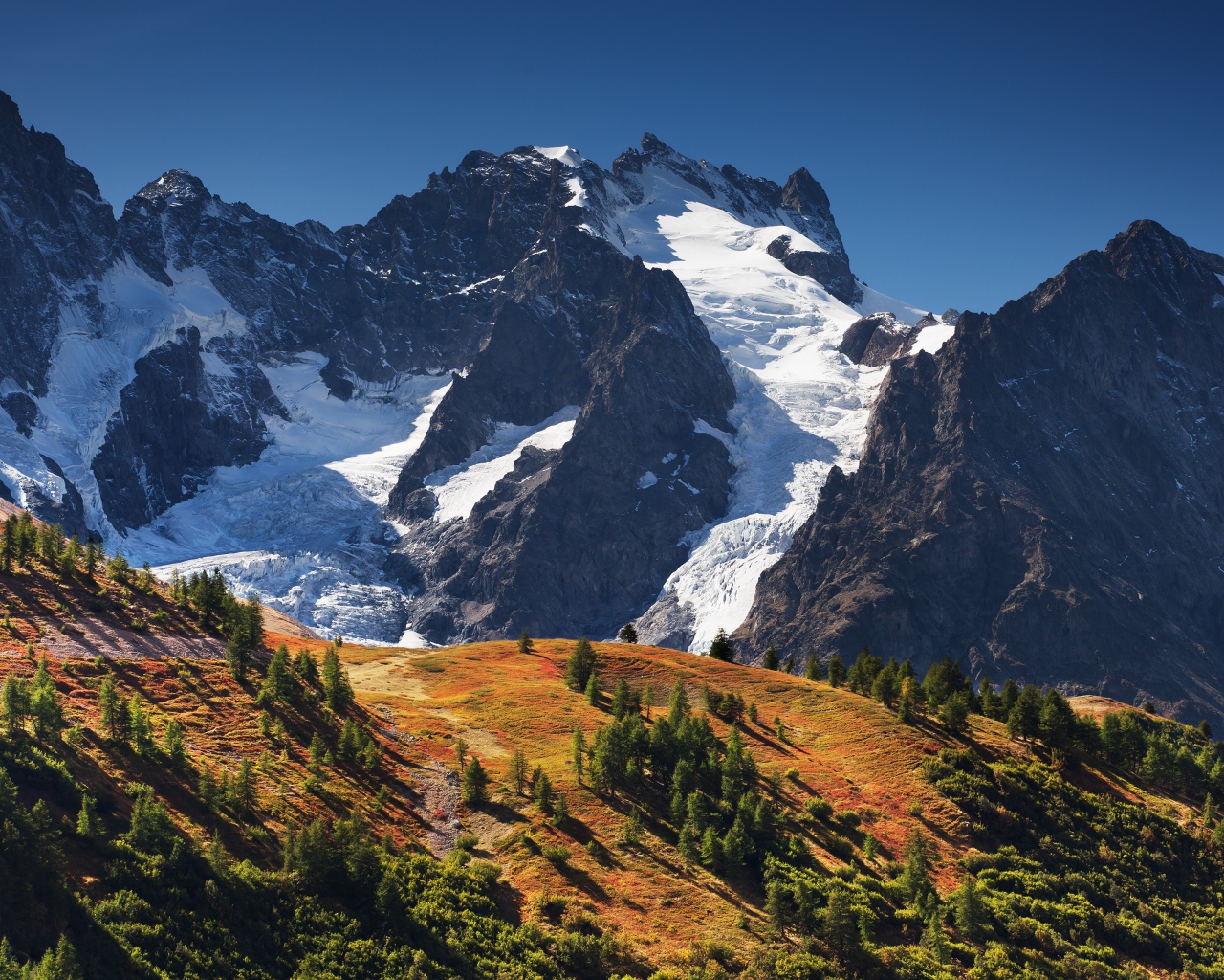 Заснеженные горы на фоне голубого неба 