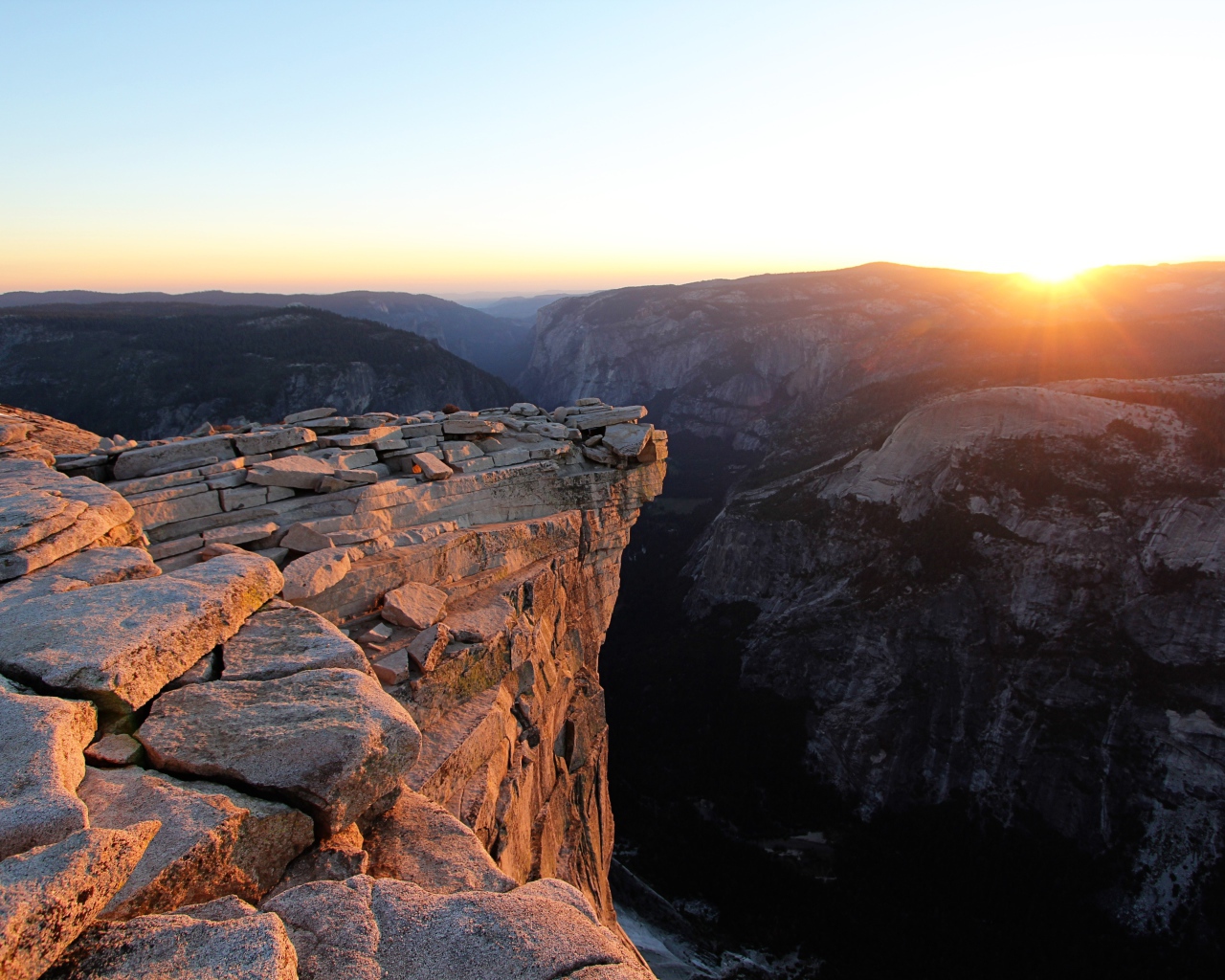 Каменные горы на фоне солнца на закате