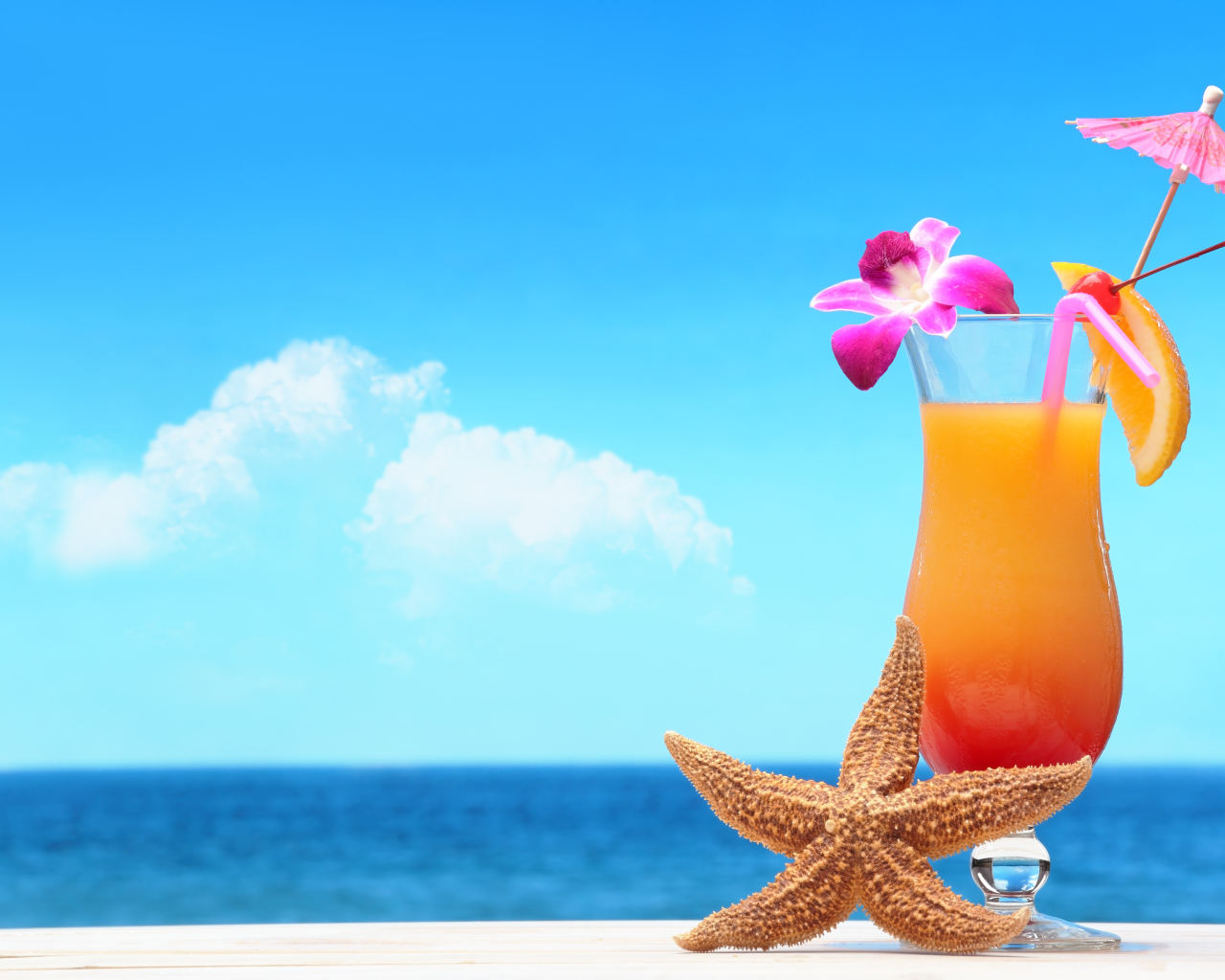 Летний коктейль и морская звезда на фоне  моря