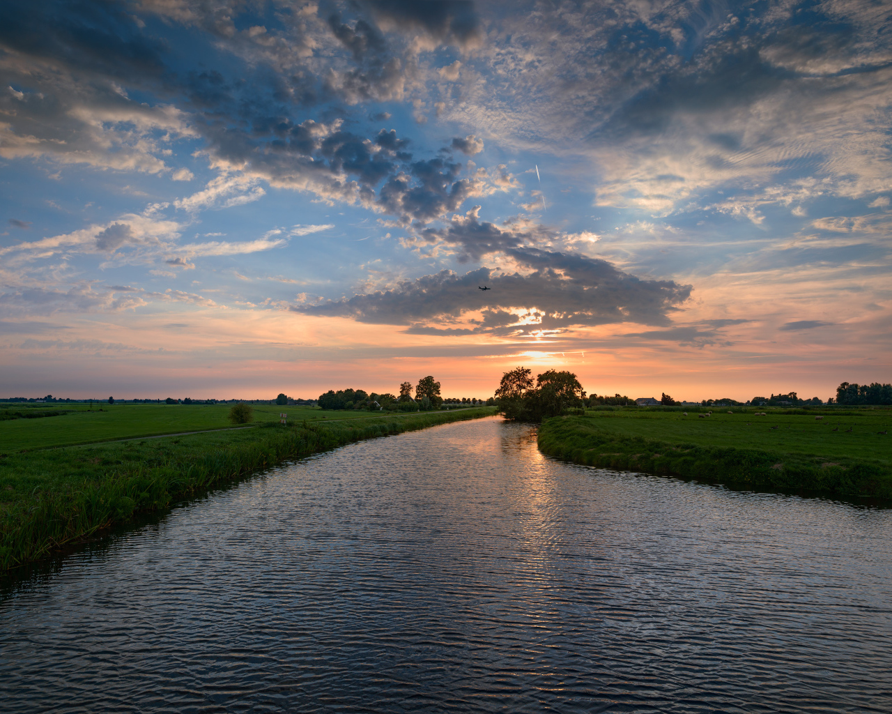 Закат солнца в облаках  над спокойной рекой