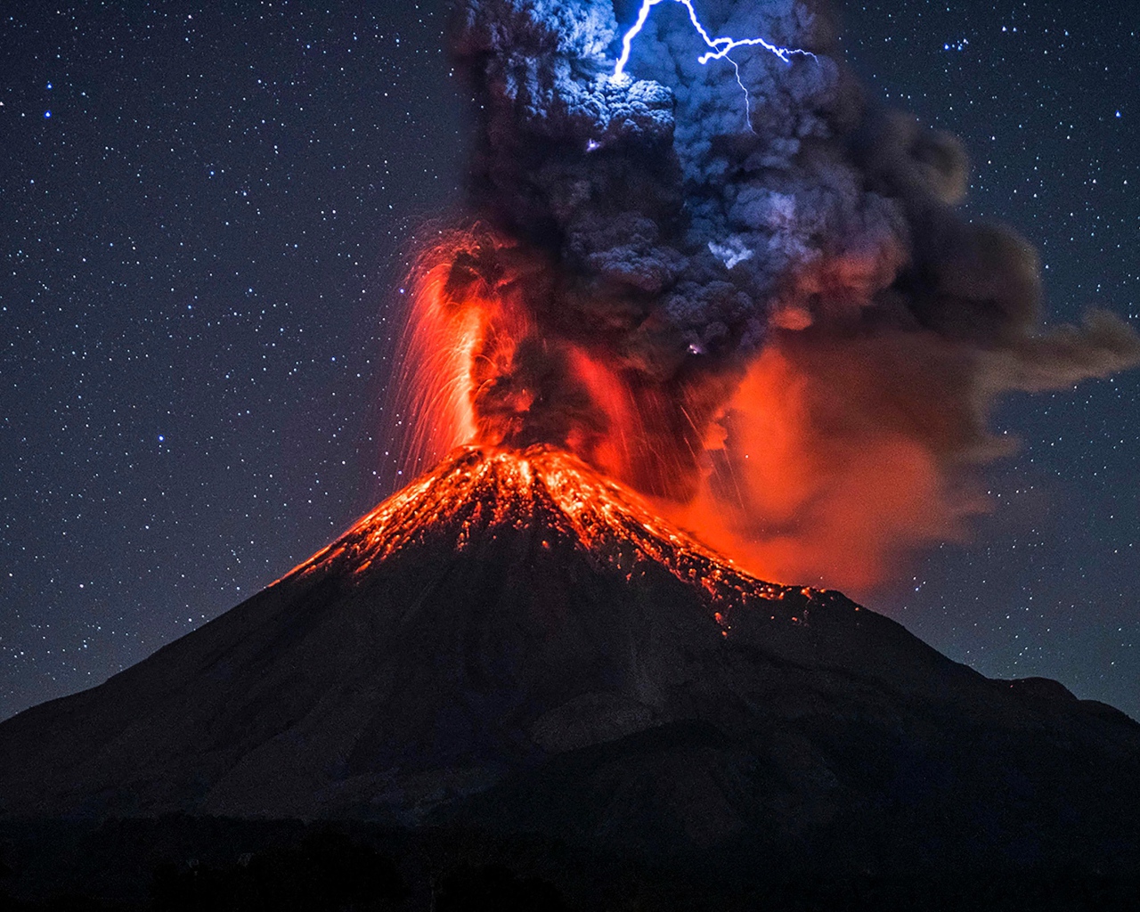 Молния над черным дымом извергающегося вулкана Колима 