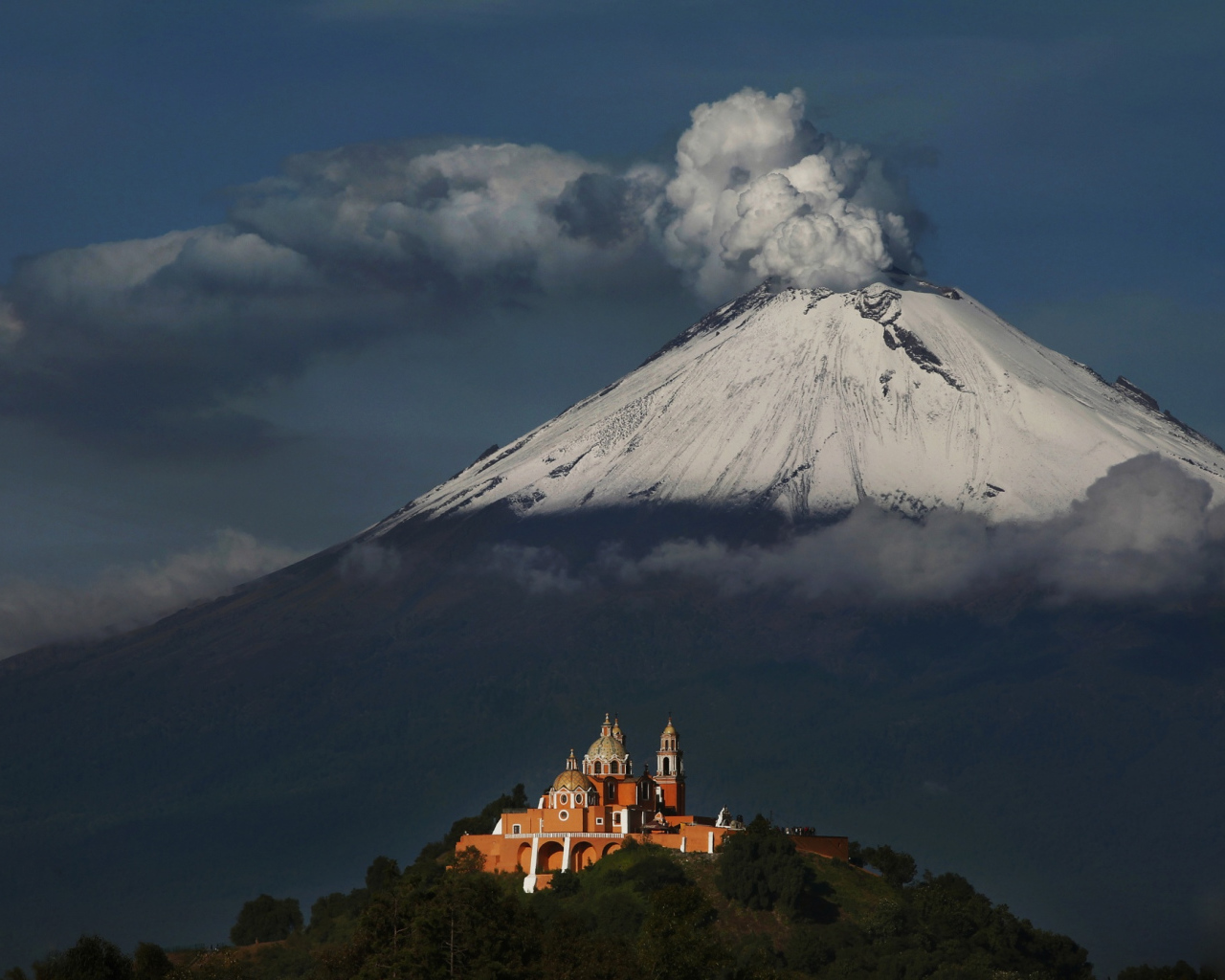 Дымящаяся вершина вулкана Попокатепетль в лучах солнца 