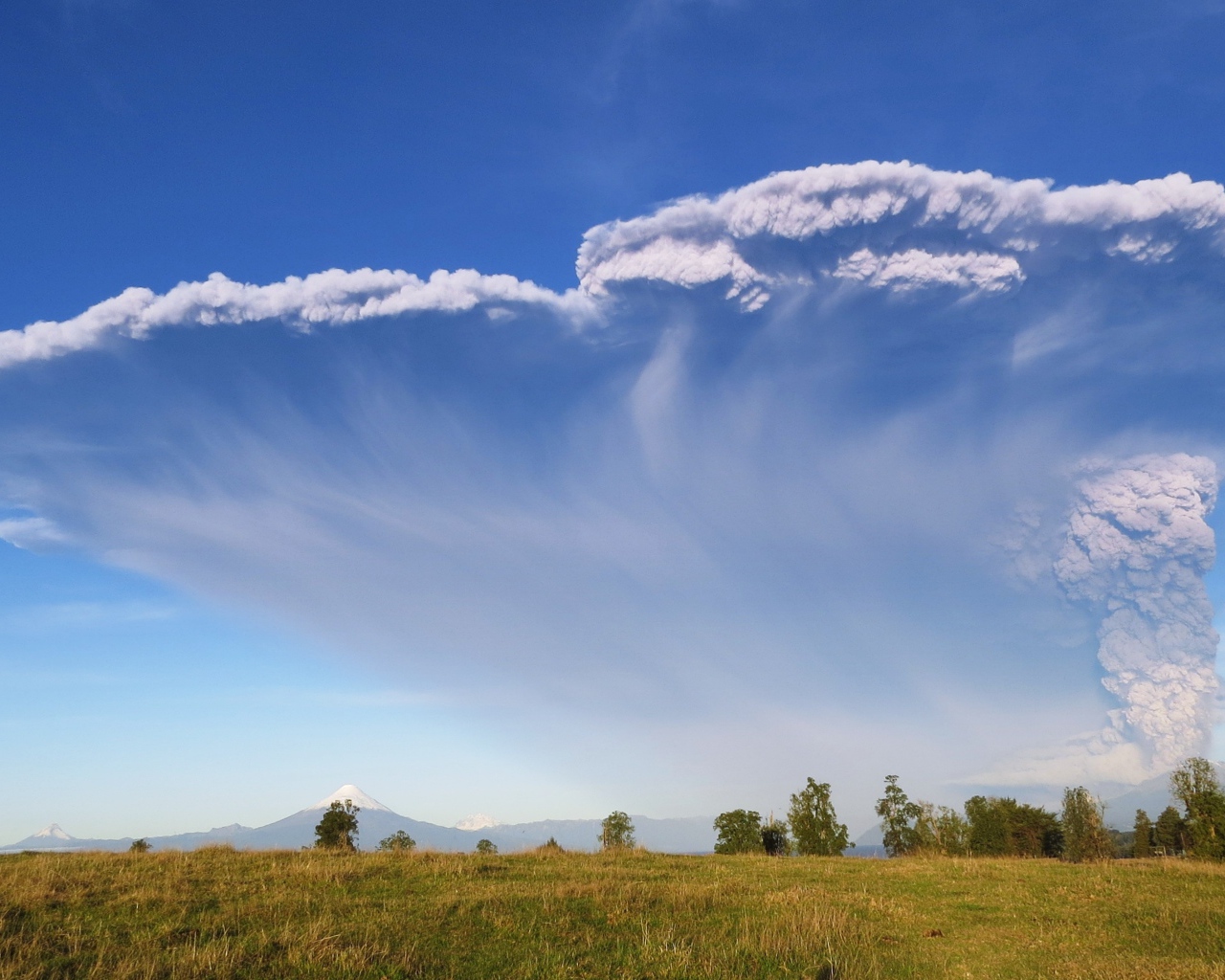 Белый дым активного вулкана Кальбуко в голубом небе, Чили