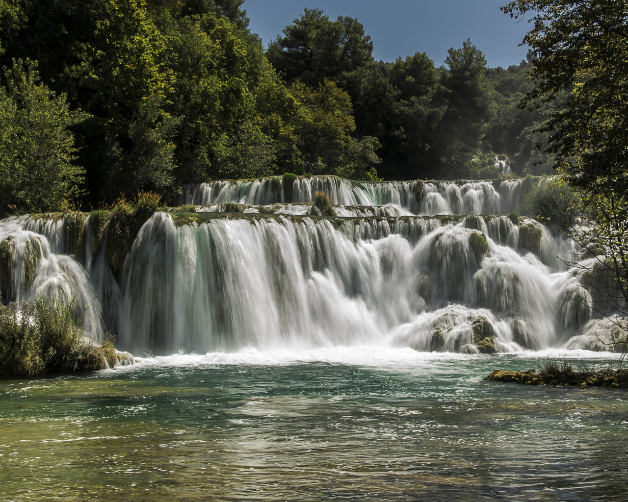 Быстрый водопад впадает в реку 