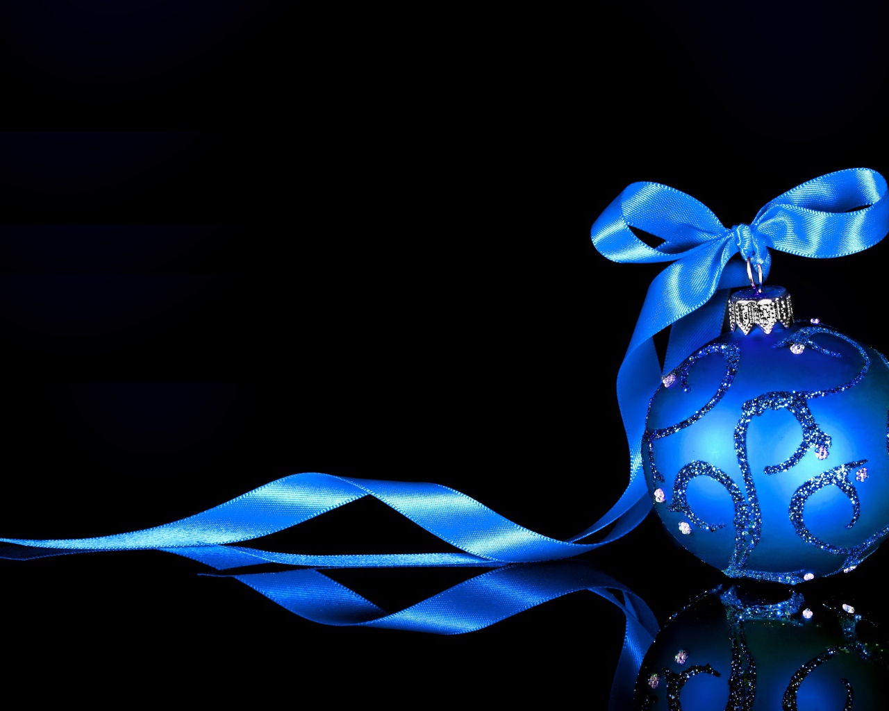 Красивый елочный шар с голубой лентой на черном фоне
