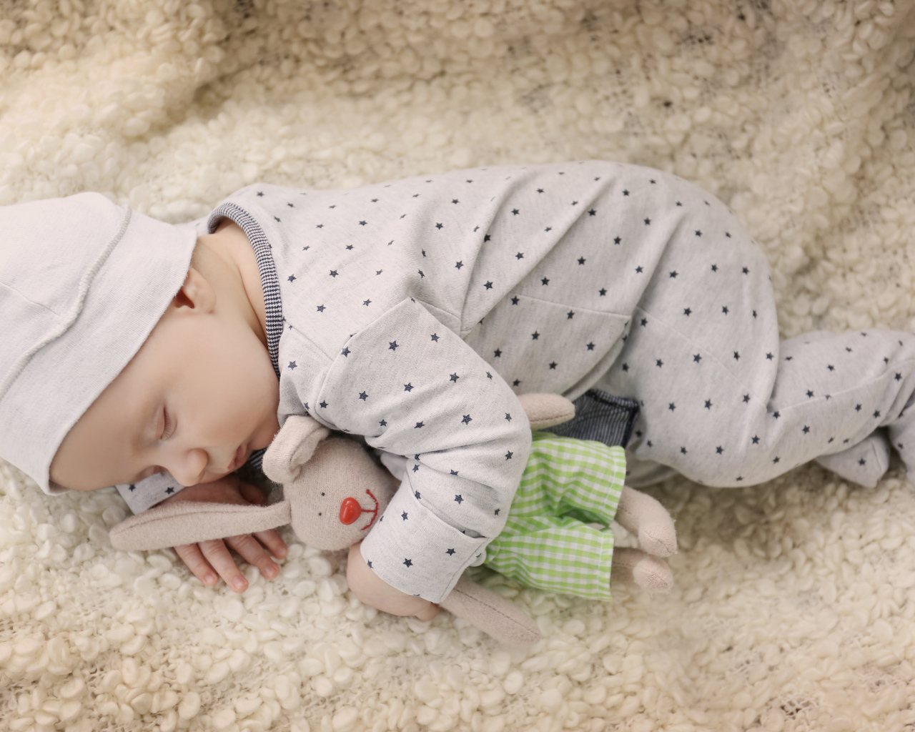 Грудной ребенок спит с любимой мягкой игрушкой