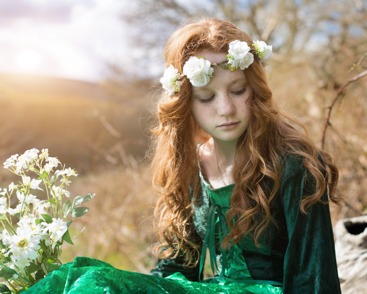 Милая рыжеволосая девочка в зеленом платье с венком на голове