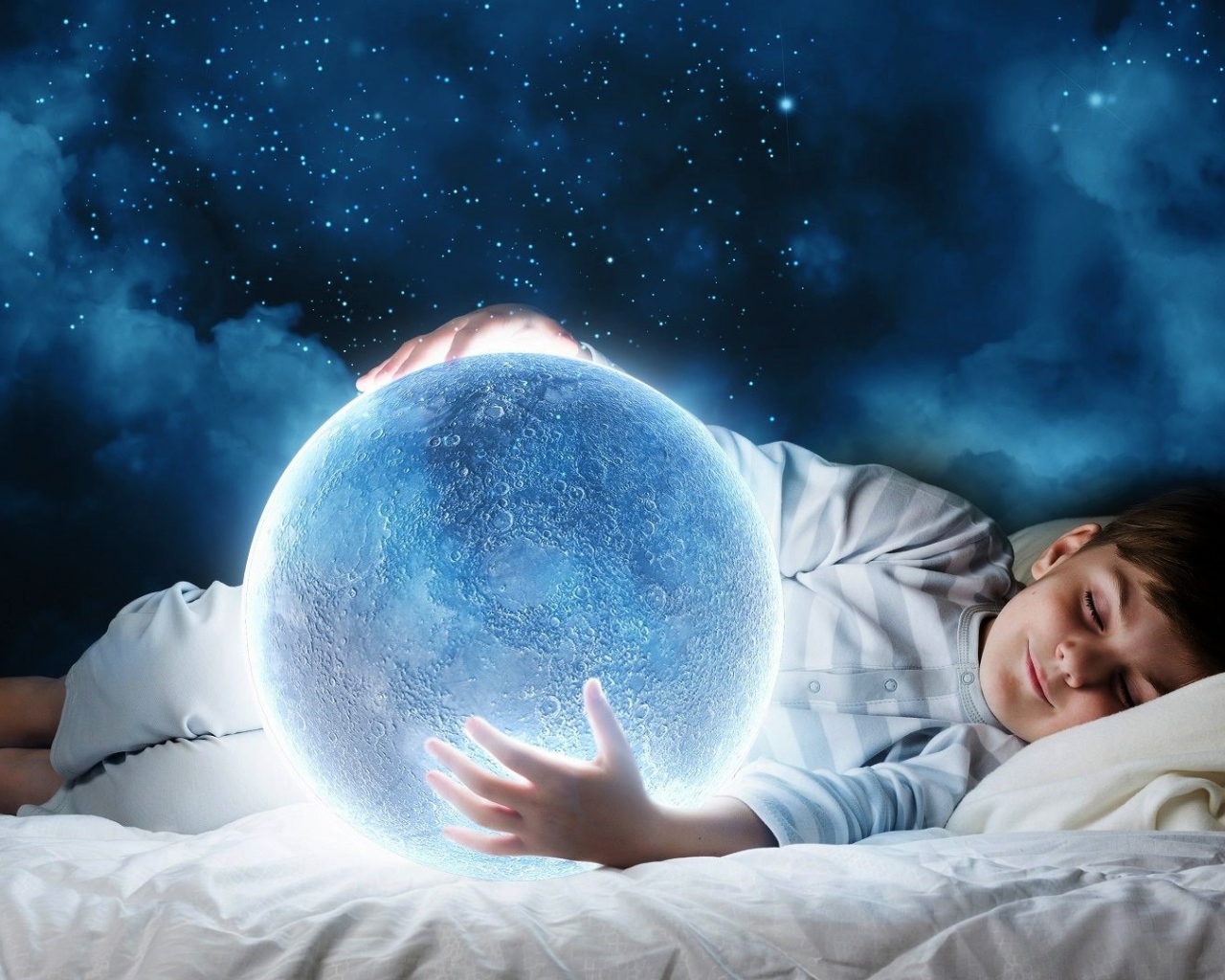 Маленький мальчик во сне держит в руках волшебную голубую луну