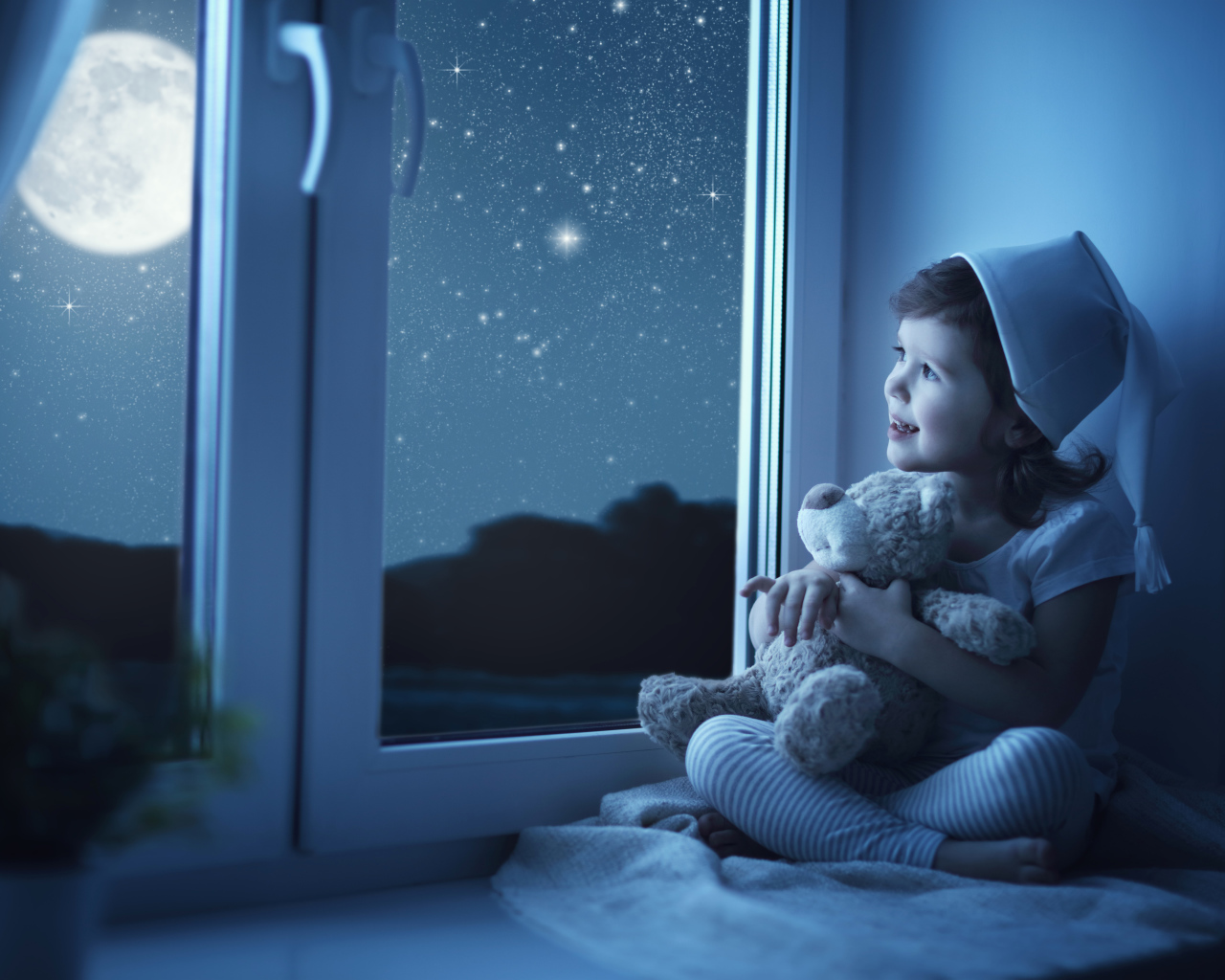 Маленькая девочка сидит на подоконнике с игрушкой ночью