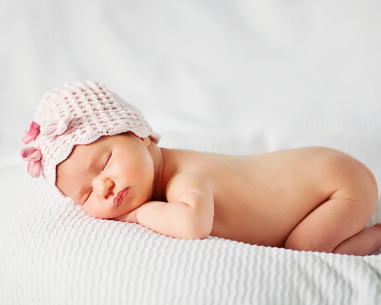 Спящий младенец девочка в розовой шапке