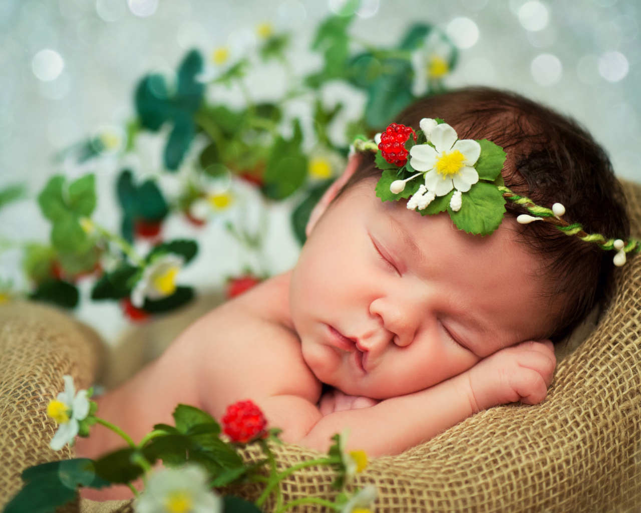 Спящий грудной ребенок с красивой повязкой на голове