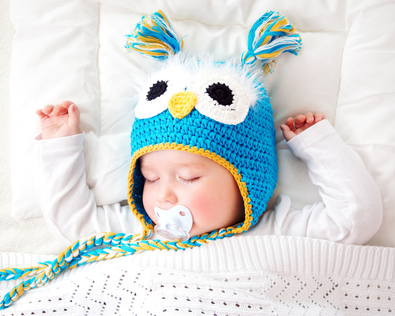 Спящий ребенок в забавной вязаной шапке