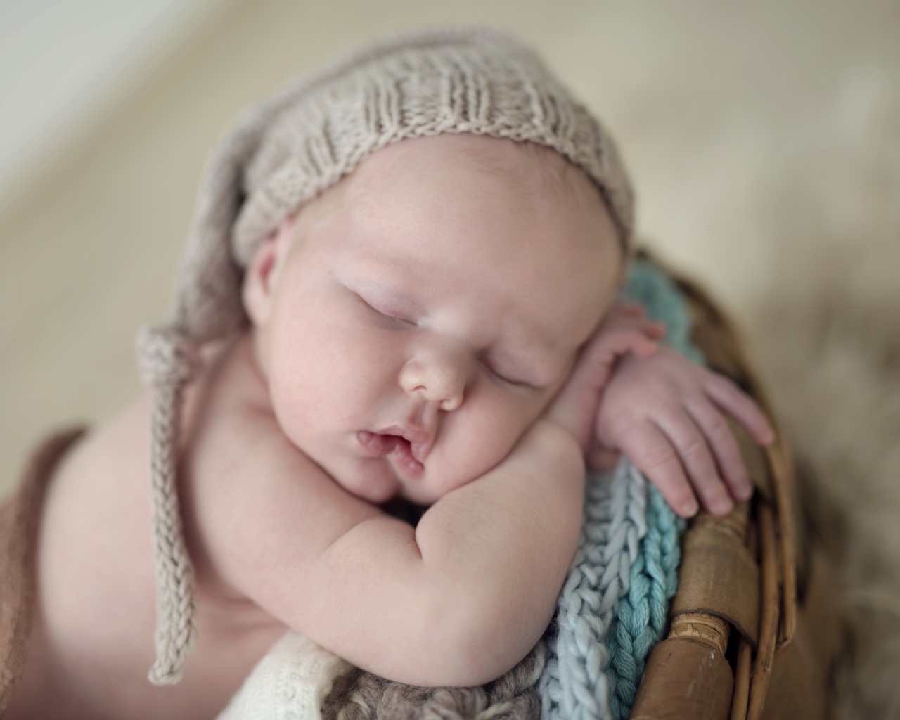 Маленький грудной ребенок спит в вязаной шапке