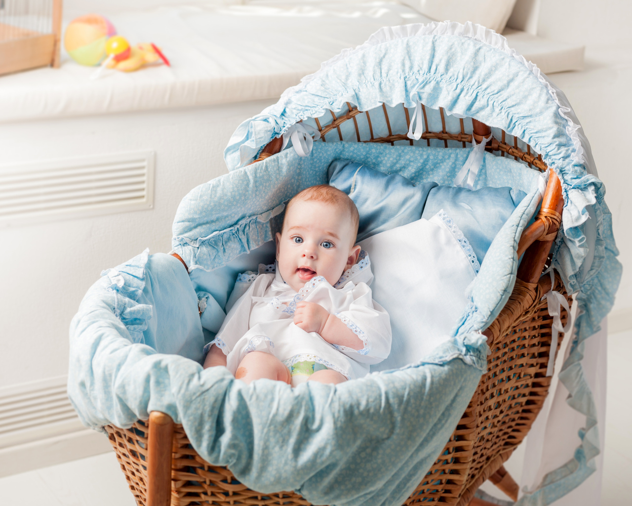 Маленький голубоглазый младенец в кроватке