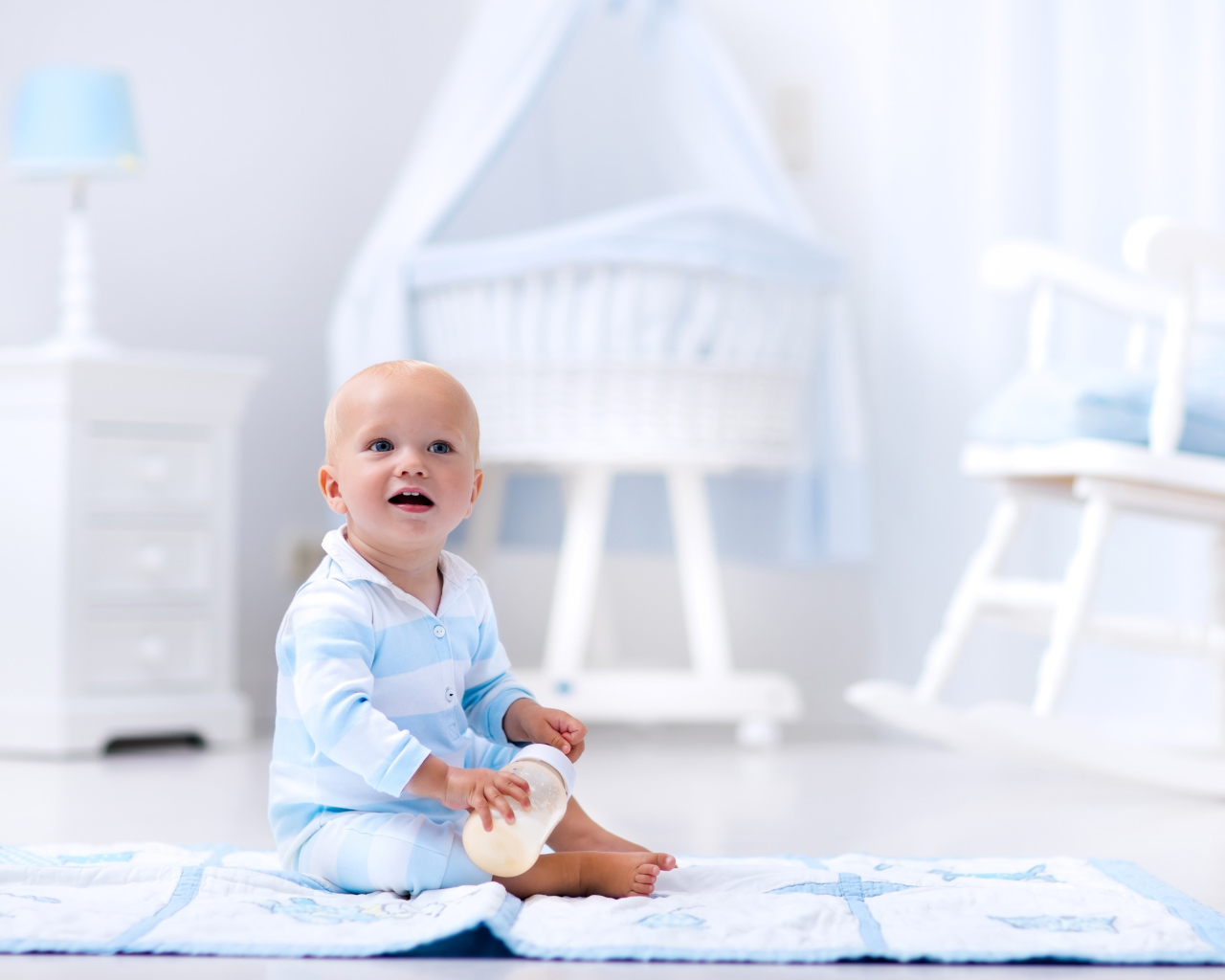 Маленький голубоглазый мальчик сидит на полу в комнате