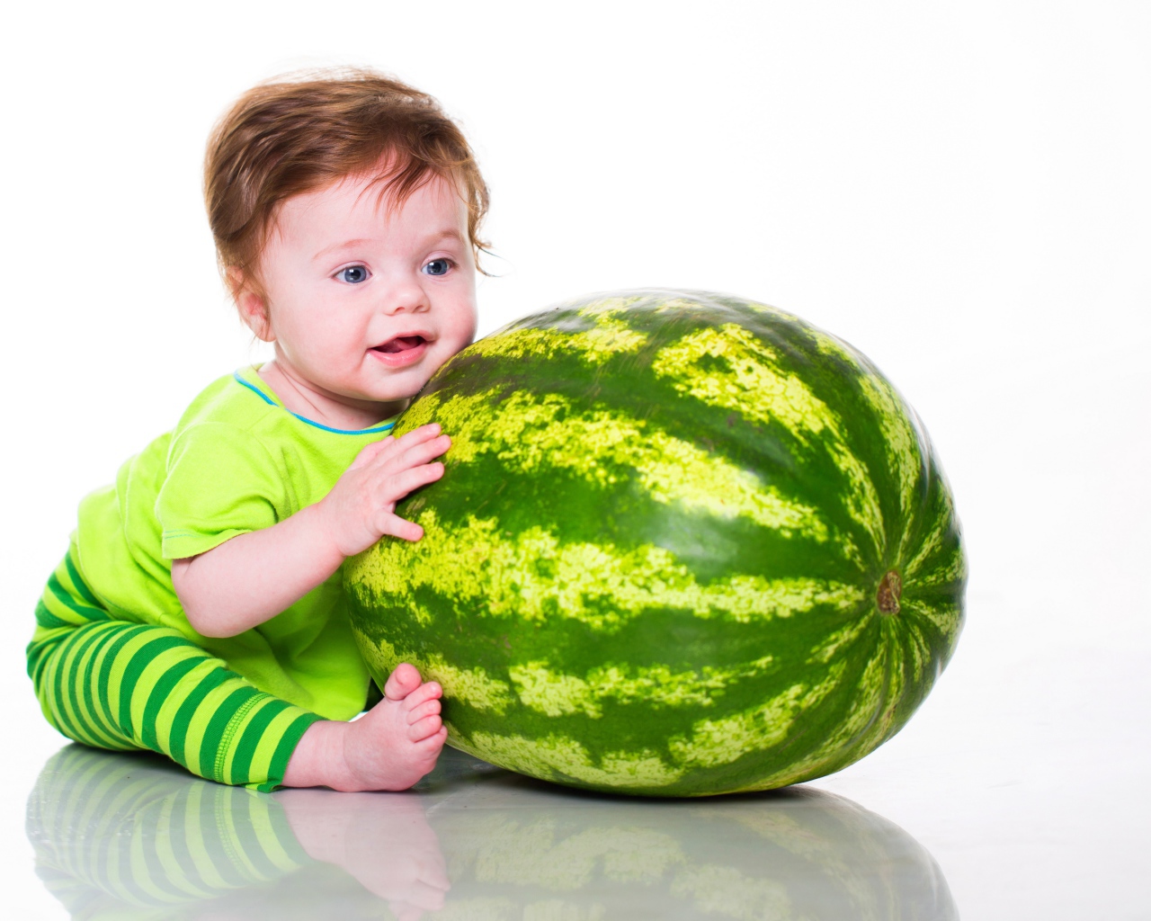 Маленький голубоглазый мальчик с большим зеленым арбузом