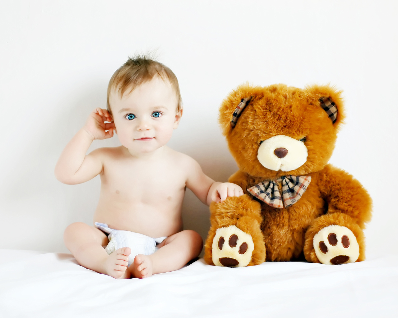 Маленький голубоглазый ребенок с большим плюшевым медведем