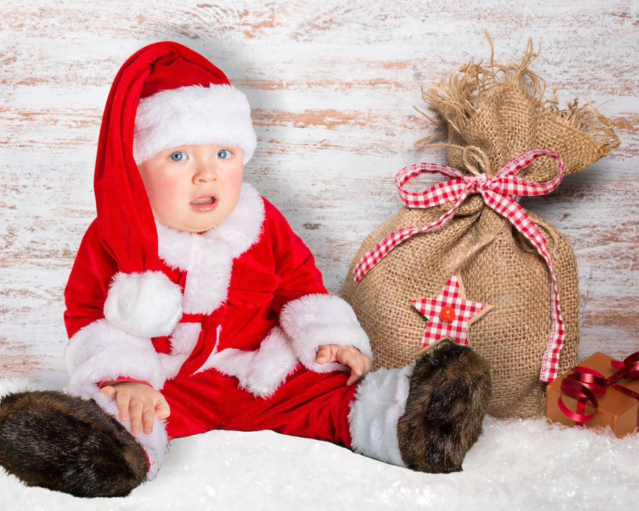Маленький ребенок в костюме Санты с мешком