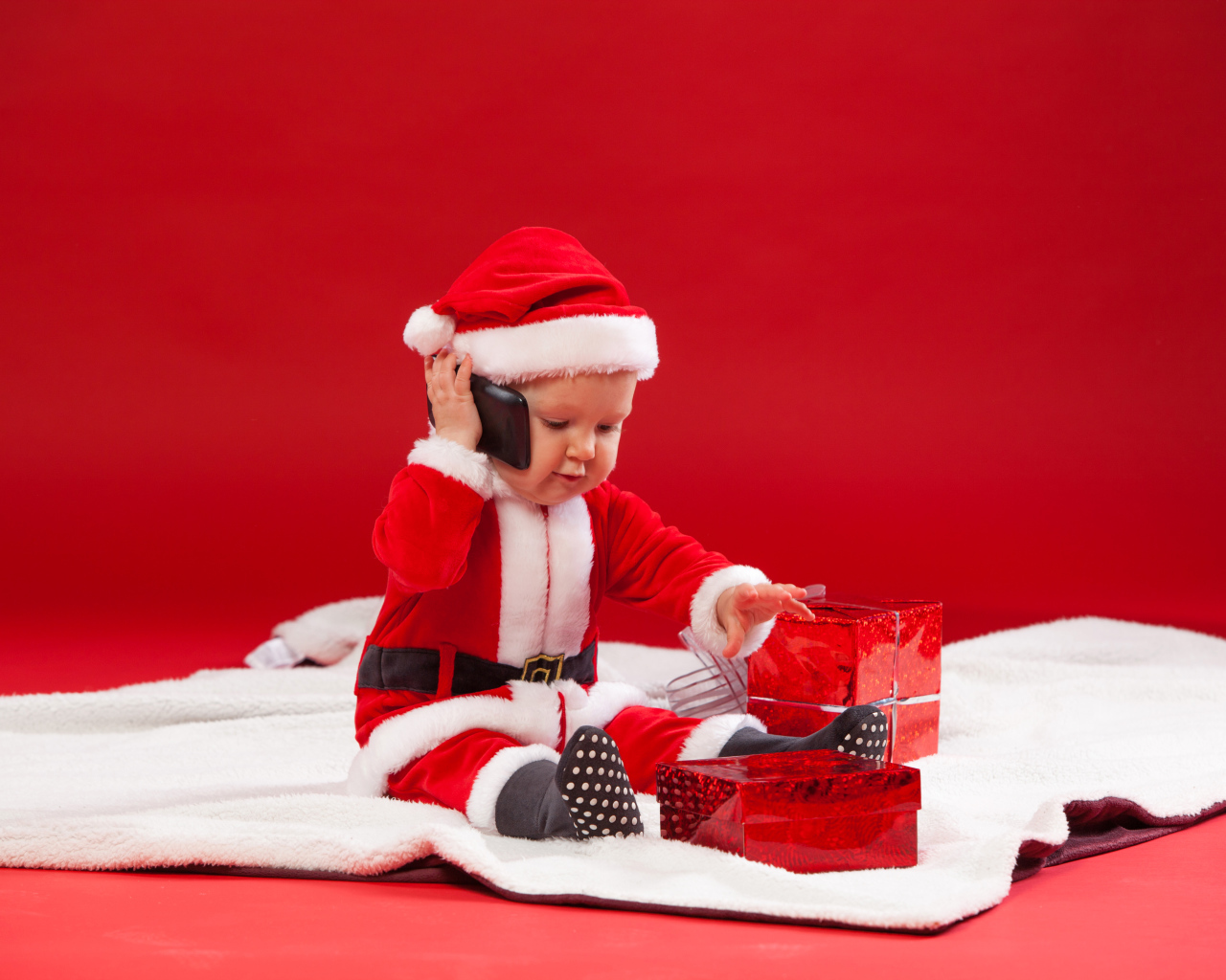 Маленький ребенок в новогодней униформе с подарками