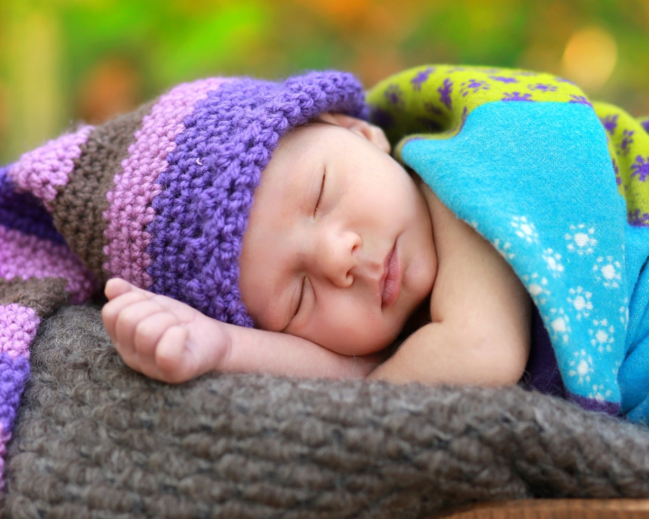 Маленький спящий младенец в вязаной шапке 