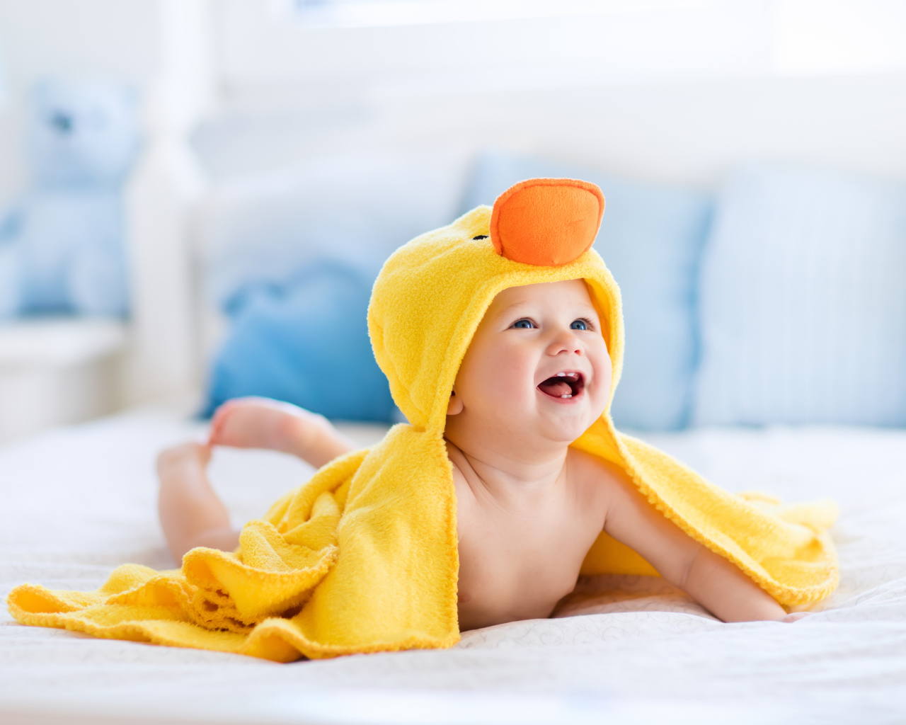 Маленький улыбающийся грудной ребенок в костюме утенка