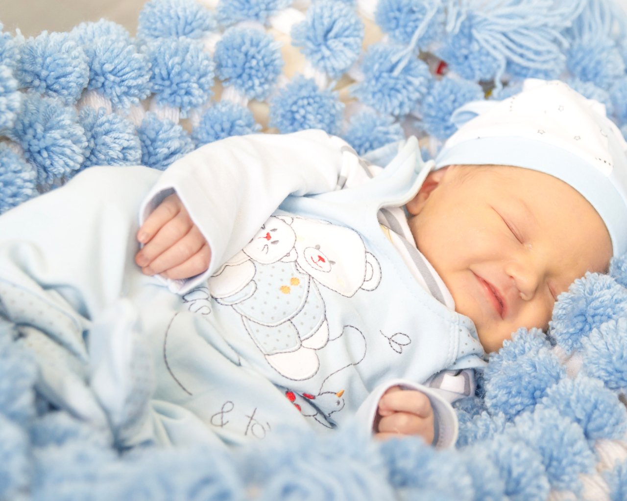 Младенец мальчик улыбается во сне