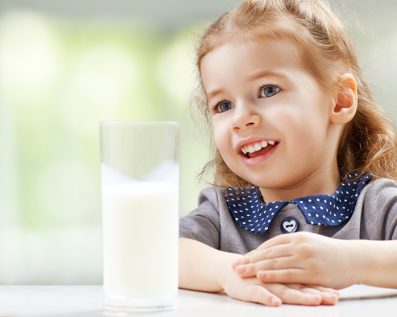 Красивая кареглазая девочка со стаканом молока