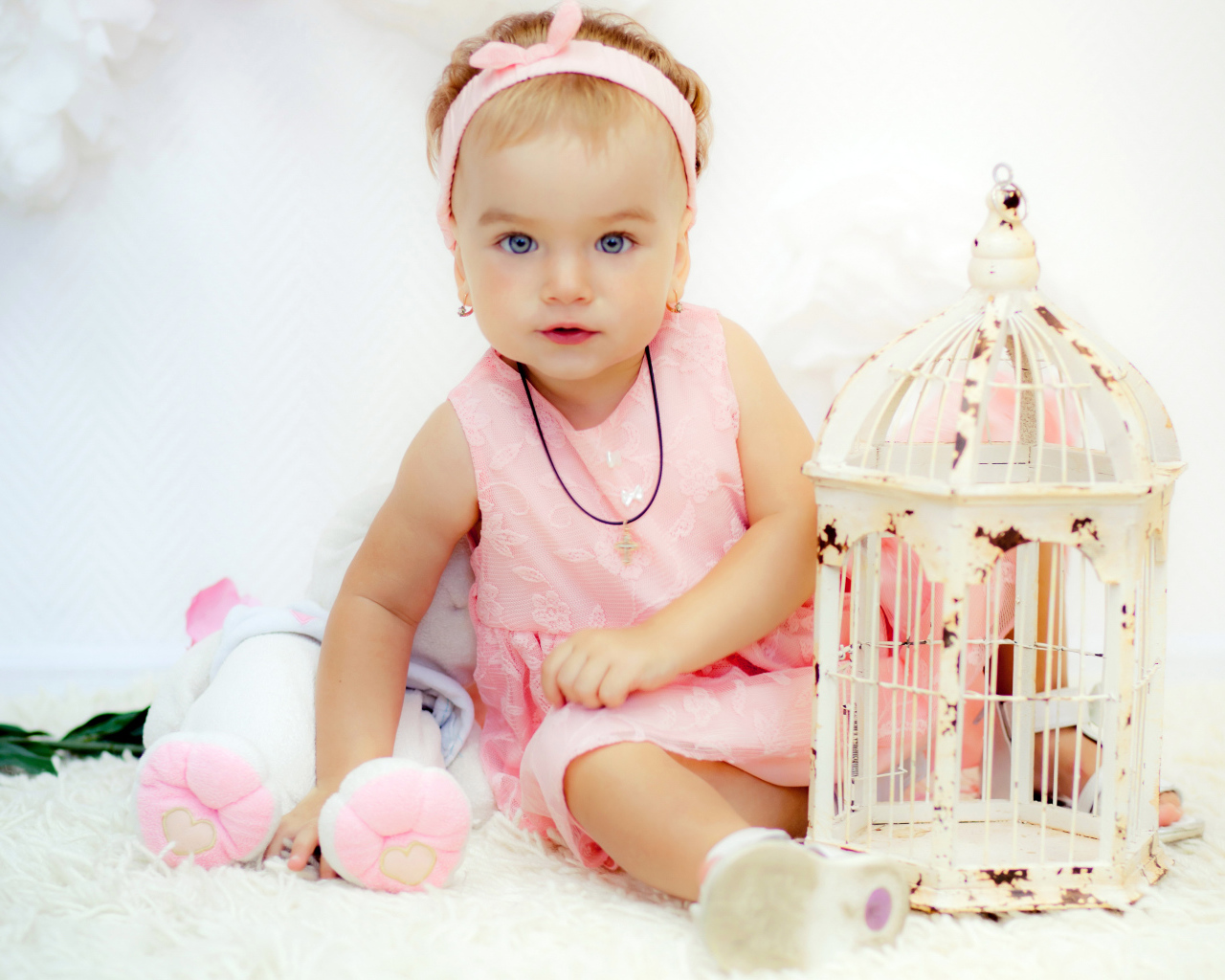 Красивая маленькая девочка в розовом платье с клеткой