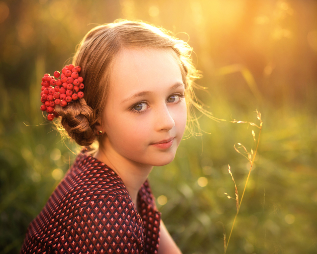 Красивая маленькая девочка с ягодами калины в волосах