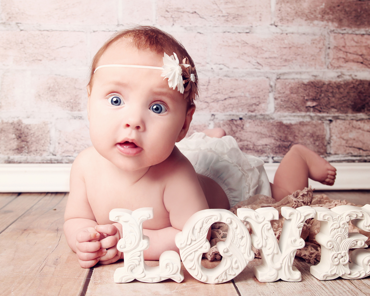 Грудной ребенок с надписью любовь на фоне кирпичной стены