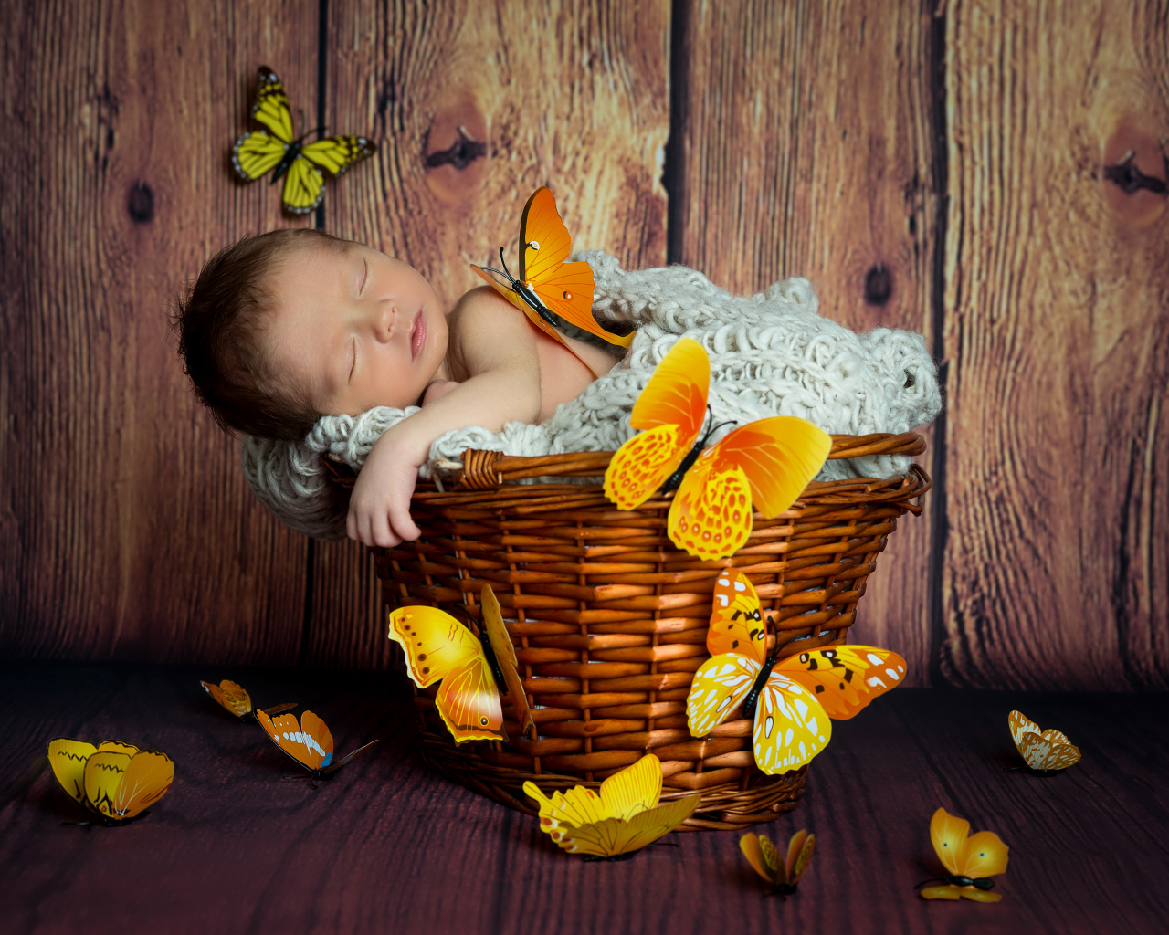 Милый спящий младенец в корзине с бабочками